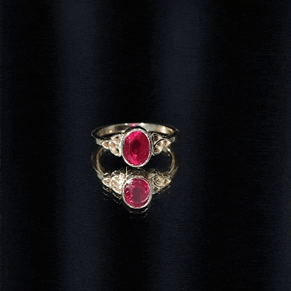 Oval-shaped 1.5 carat lab-grown ruby Celtic engagement ring with bezel setting by Rosec Jewels, displayed on a yellow background.