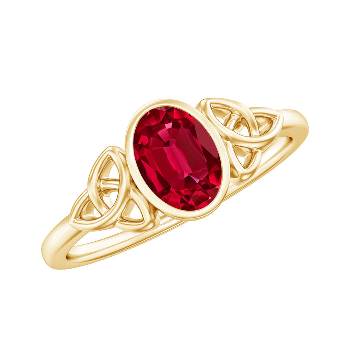 Oval-shaped 1.5 carat lab-grown ruby Celtic engagement ring in bezel setting by Rosec Jewels, featuring intricate design and silver band.