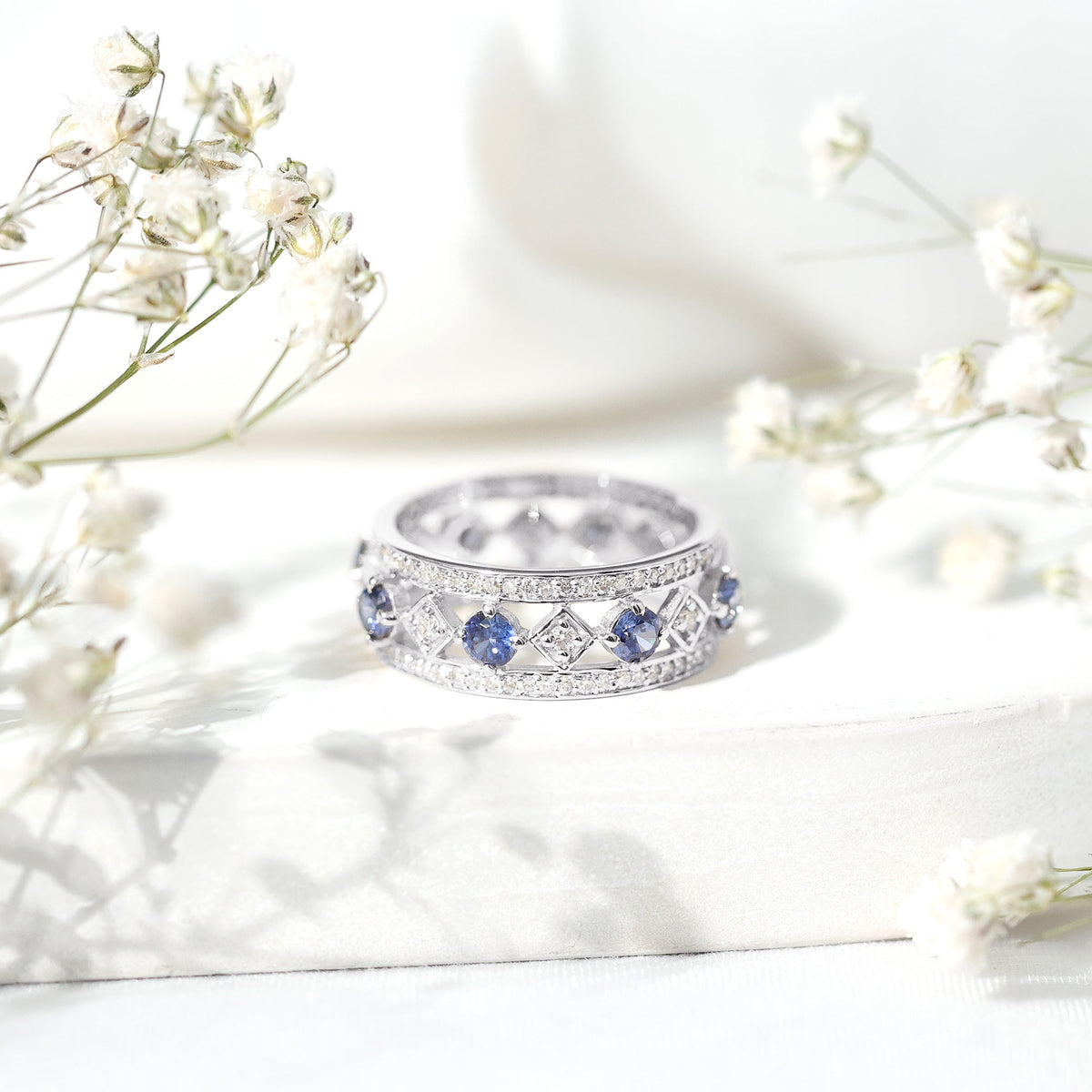 Lab-created blue sapphire and diamond full eternity band ring by Rosec Jewels, showcasing sparkling gemstones and elegant design.