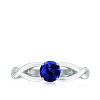 Lab-grown blue sapphire promise ring with a surprise diamond, featuring a 0.6-carat stone set in a rose gold band.