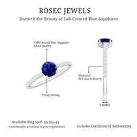 Lab-created blue sapphire promise ring with diamond side stones, showcasing a 5mm blue sapphire centerpiece and elegant design.