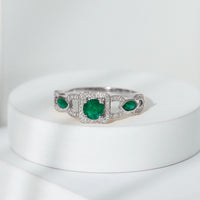 Vintage style emerald and diamond engagement ring for women by Rosec Jewels, featuring a central emerald surrounded by diamonds.