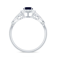 Vintage blue sapphire engagement ring with diamond halo, featuring intricate detailing and a rose gold band by Rosec Jewels.