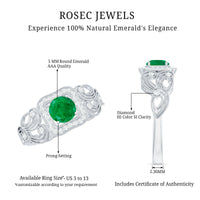 Vintage-style emerald engagement ring with diamond halo by Rosec Jewels, featuring intricate metalwork and sparkling gemstones.