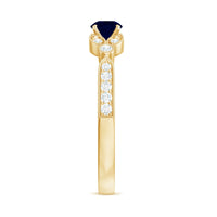 Vintage inspired blue sapphire and diamond engagement ring with milgrain details, showcasing intricate craftsmanship and elegant design.