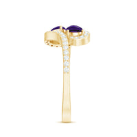Vintage-inspired amethyst and diamond bypass engagement ring with two stones, featuring intricate metalwork and elegant design.