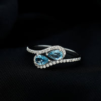 Genuine aquamarine two-stone engagement ring with diamonds, featuring a rose gold band and intricate detailing.