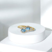 Genuine aquamarine two-stone engagement ring with diamonds, showcasing a elegant rose gold band and detailed craftsmanship.