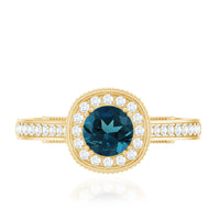 Vintage London Blue Topaz engagement ring with diamond halo, featuring intricate detailing and sterling silver band by Rosec Jewels.