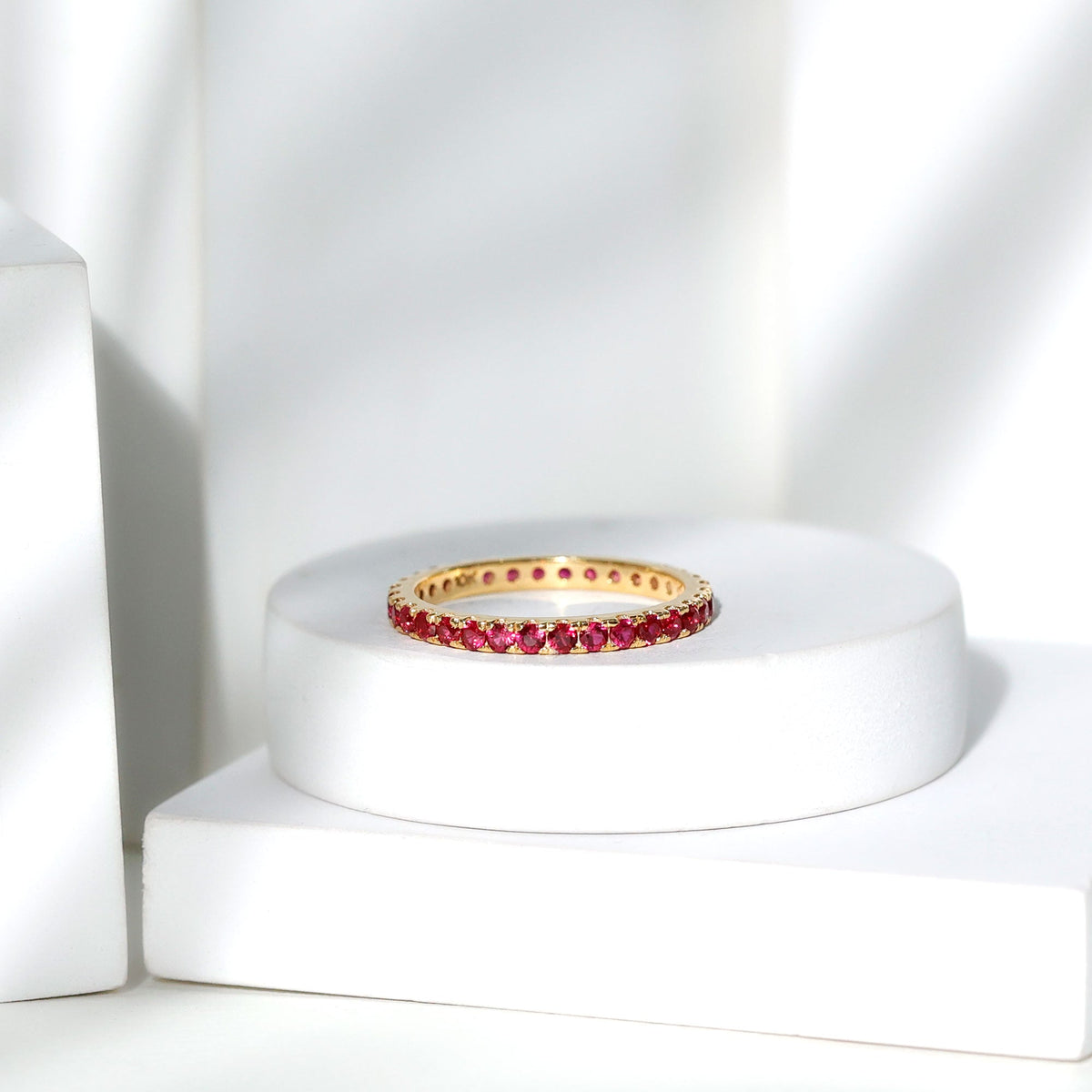 Rosec Jewels French pave set lab-grown ruby stackable eternity ring with sparkling ruby accents and a sleek gold band.