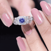 Vintage-style tanzanite engagement ring with diamond halo, featuring yellow gold band and intricate detailing by Rosec Jewels.