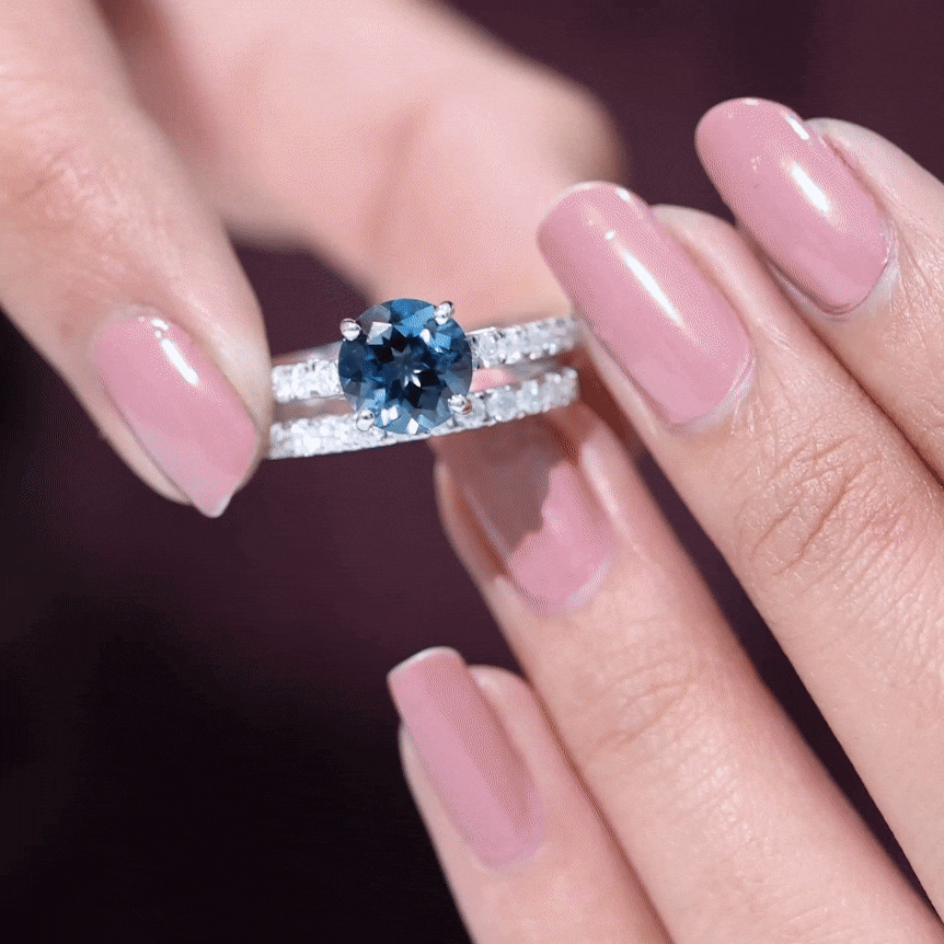 Two Rosec Jewels 2 Carat round London Blue Topaz solitaire rings with moissanite bands, showcasing elegant gemstone settings.
