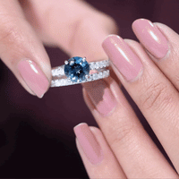 Two 2-carat round London Blue Topaz solitaire rings with moissanite bands, showcasing elegant jewelry by Rosec Jewels.