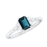 Emerald cut London Blue Topaz engagement ring with diamond trio by Rosec Jewels, showcasing the stunning gemstone and elegant band.