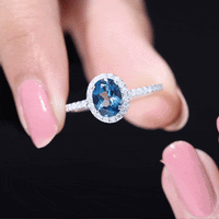 Oval cut London Blue Topaz engagement ring with diamond halo, set in a classic style by Rosec Jewels.