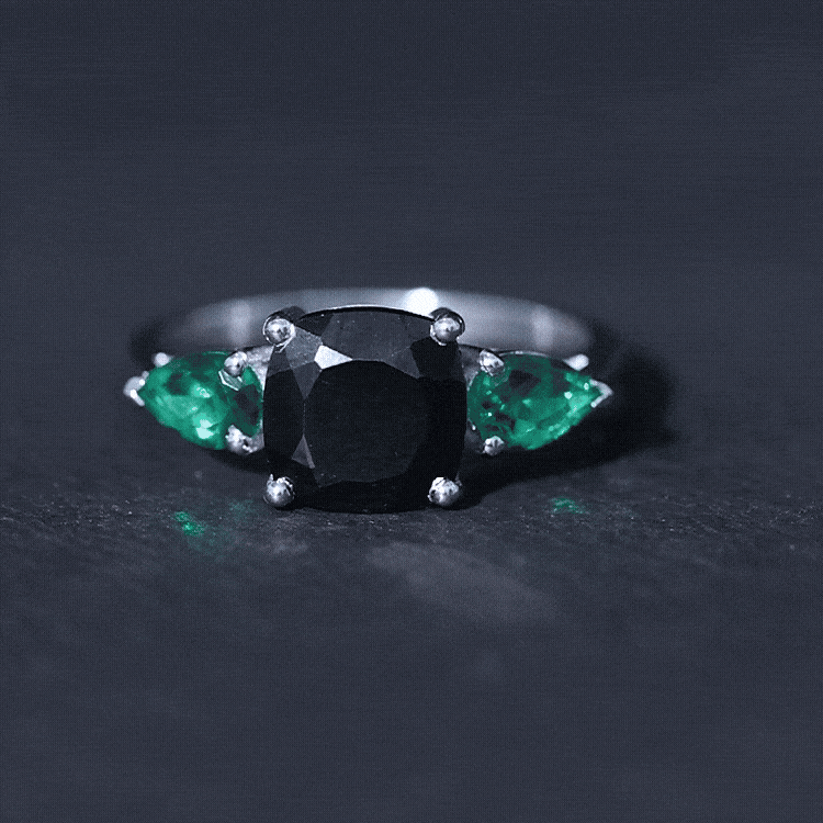 Rosec Jewels 2.8 carat lab-grown black diamond 3-stone engagement ring with emerald accents, showcasing a yellow gold band.