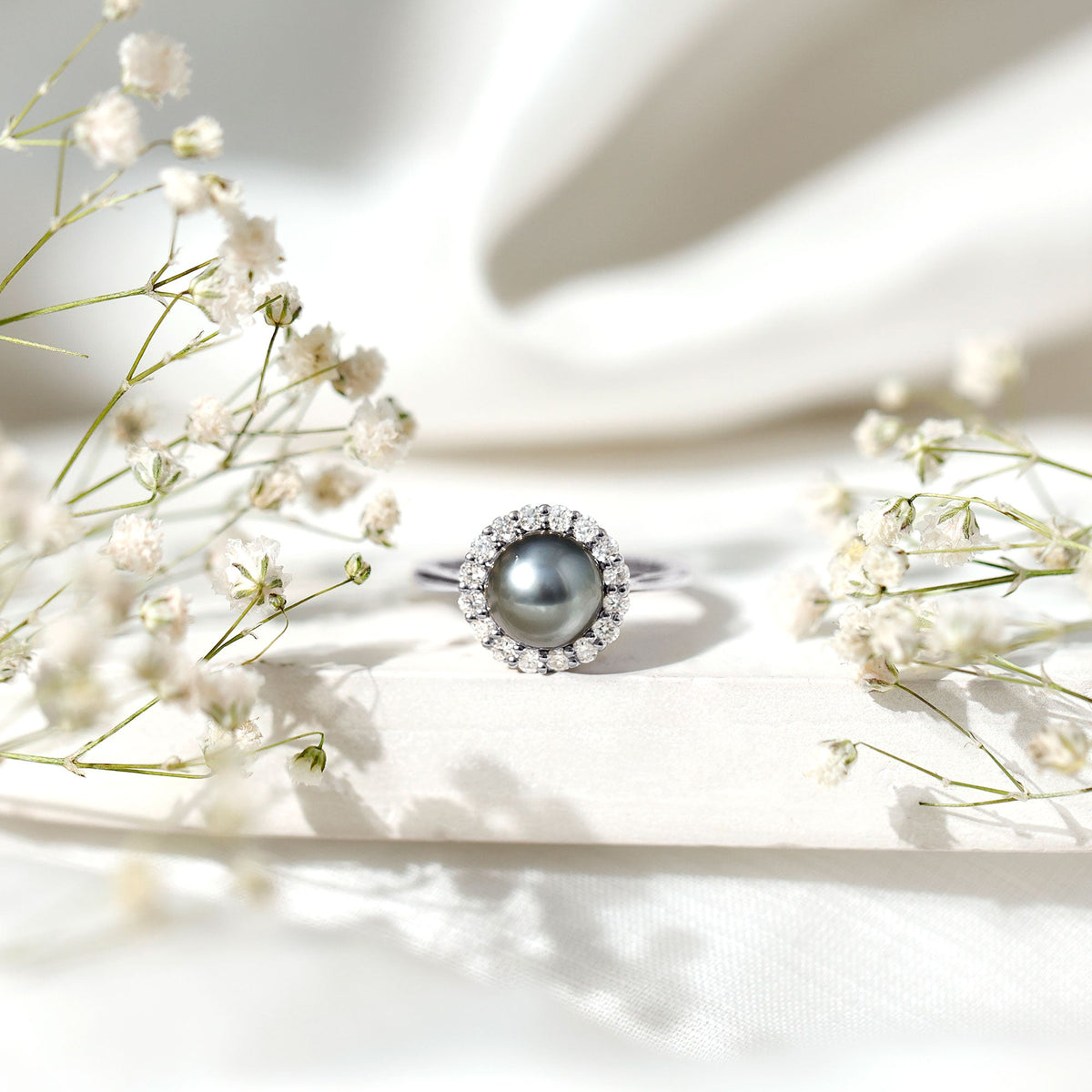 Natural Tahitian pearl and diamond halo engagement ring from Rosec Jewels, featuring a central pearl surrounded by sparkling diamonds.
