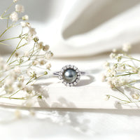 Natural Tahitian pearl and diamond halo engagement ring from Rosec Jewels, featuring a central pearl surrounded by sparkling diamonds.