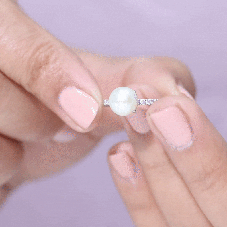 Freshwater pearl solitaire engagement ring with diamond accent, featuring a 7.4-carat pearl set in a rose gold band.