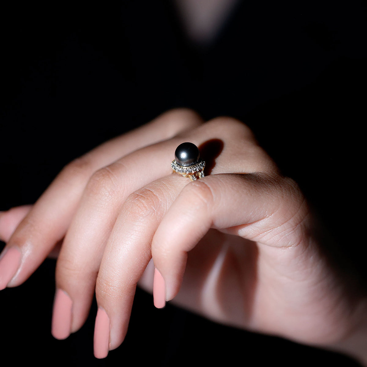 Tahitian pearl and diamond crossover engagement ring by Rosec Jewels, showcasing a large black pearl with sparkling diamonds on a gold band.