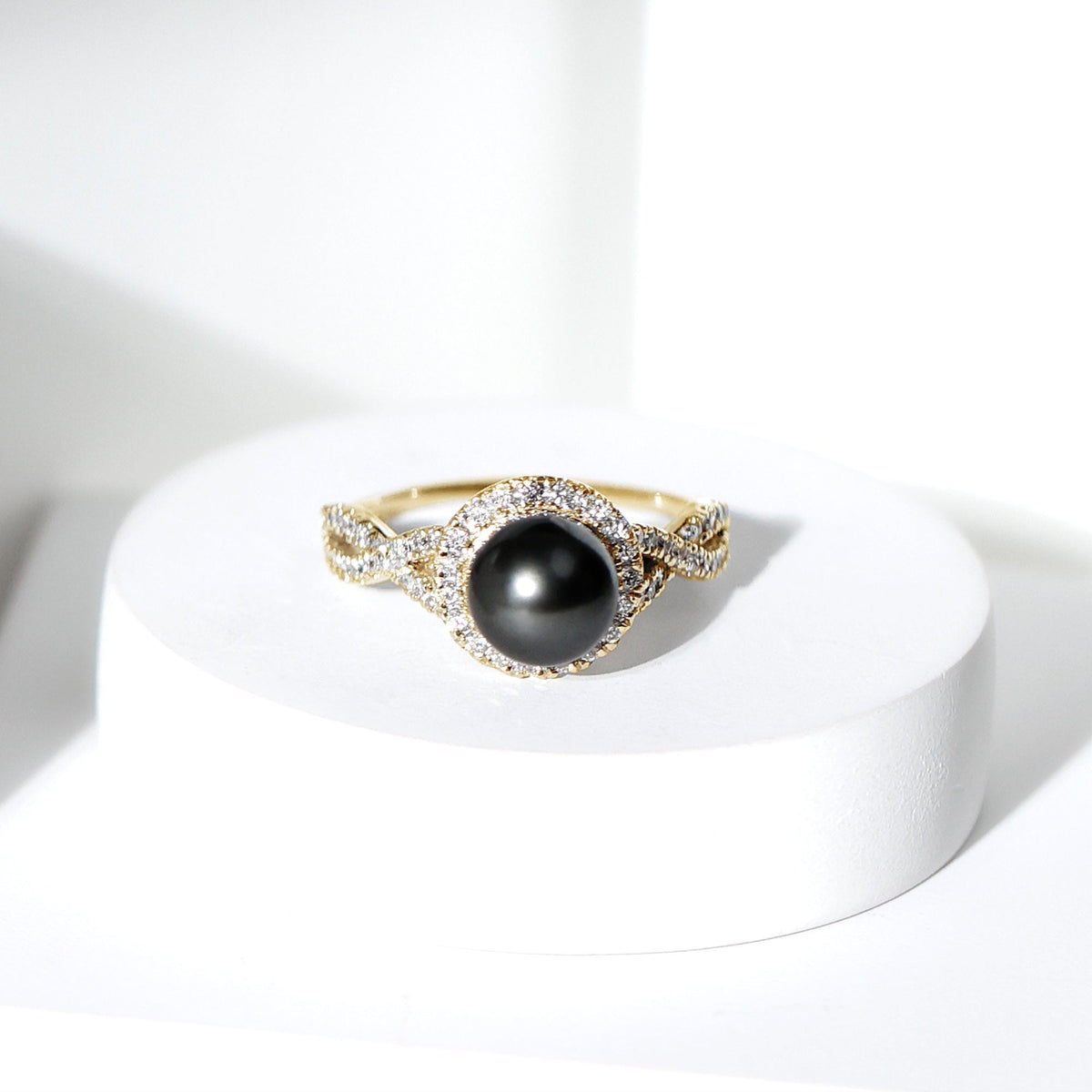 Real Tahitian pearl and diamond crossover engagement ring from Rosec Jewels showcasing a lustrous pearl and sparkling diamonds in a elegant design.