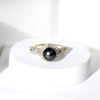 Real Tahitian pearl and diamond crossover engagement ring from Rosec Jewels showcasing a lustrous pearl and sparkling diamonds in a elegant design.