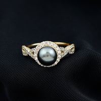 Real Tahitian pearl and diamond crossover engagement ring by Rosec Jewels, showcasing a pearl with sparkling diamonds in a sleek ring setting.