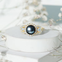 7.5 carat round black pearl engagement ring with moissanite accents by Rosec Jewels, featuring a sleek gold band and elegant design.