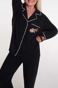 Close-up of WeloWela Wela Pajama Magnetic Shirt for women in black, showing fabric details and magnetic button closures.