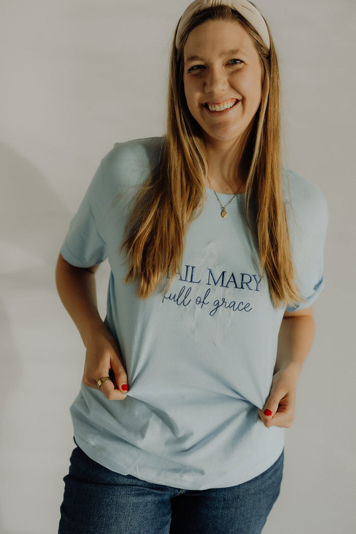 Red Hail Mary T-Shirt by Abundantly Yours Shop featuring festive Christmas design with religious imagery.
