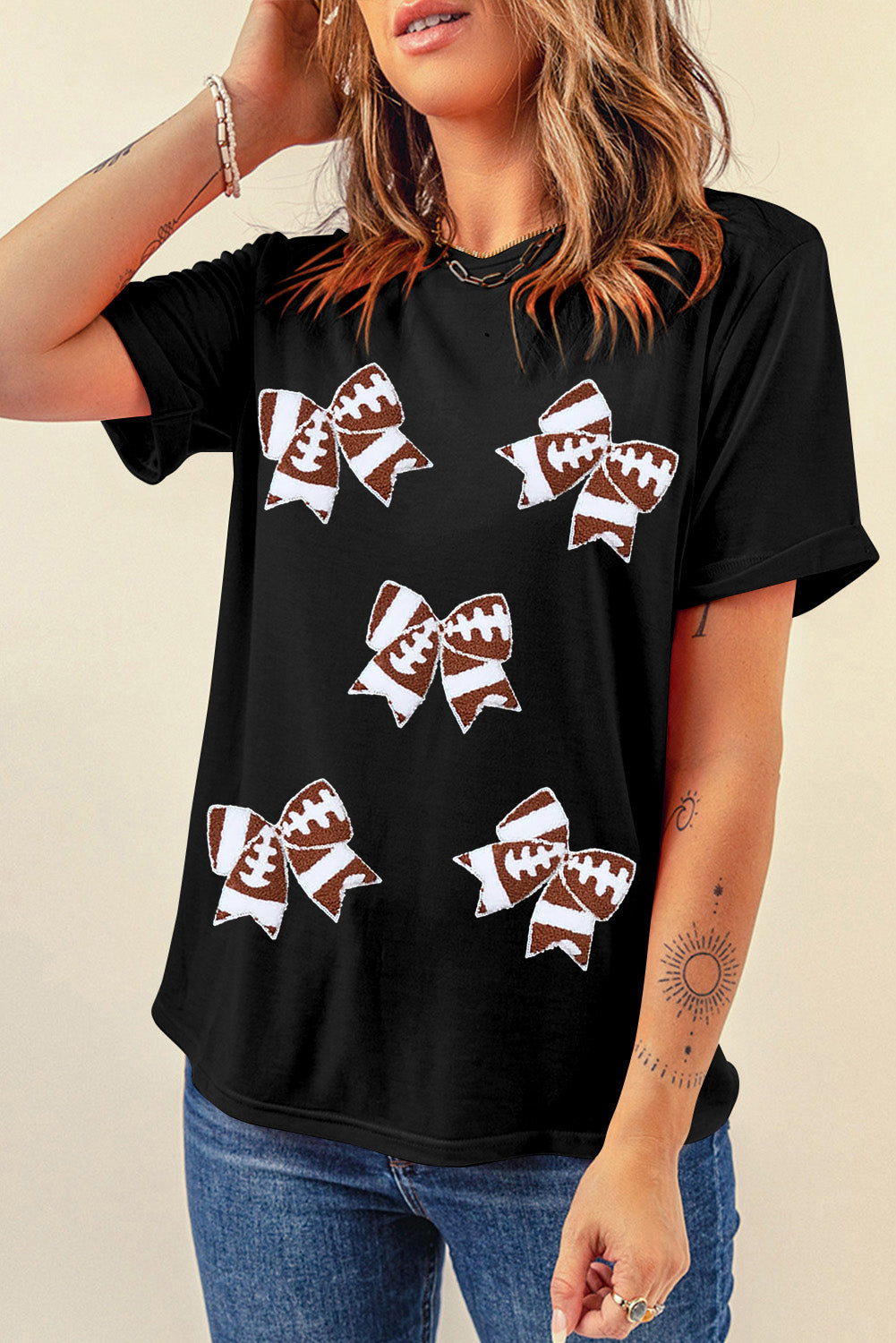 Black football-themed T-shirt with bowknot pattern, perfect for game day, by Adelyne's Boutique & Gifts.