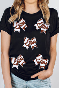Black football-themed T-shirt with bowknot pattern, perfect for game day, by Adelyne's Boutique & Gifts.