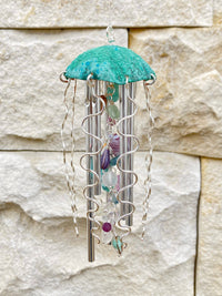 Colorful jellyfish wind chime by Alison Morse hanging outdoors with vibrant glass jellyfish shapes and gentle movement in the breeze.