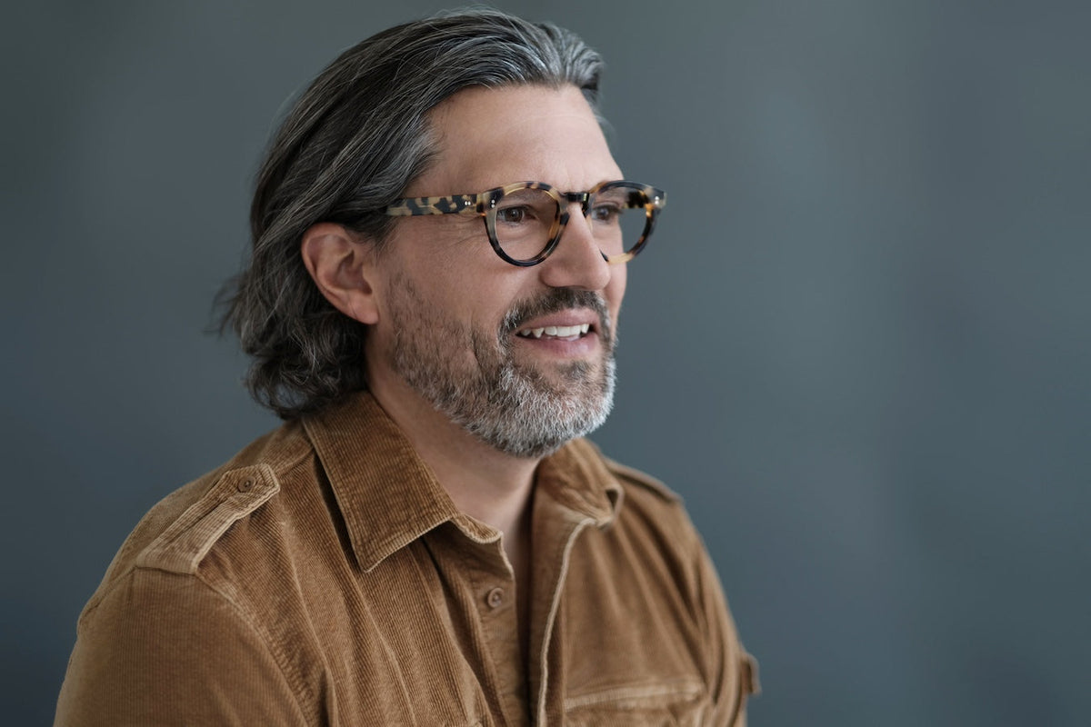 Blue translucent Carter reading glasses by Benny's Eyewear with clear lenses and stylish frame design.