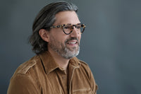 Blue translucent Carter reading glasses by Benny's Eyewear with clear lenses and stylish frame design.