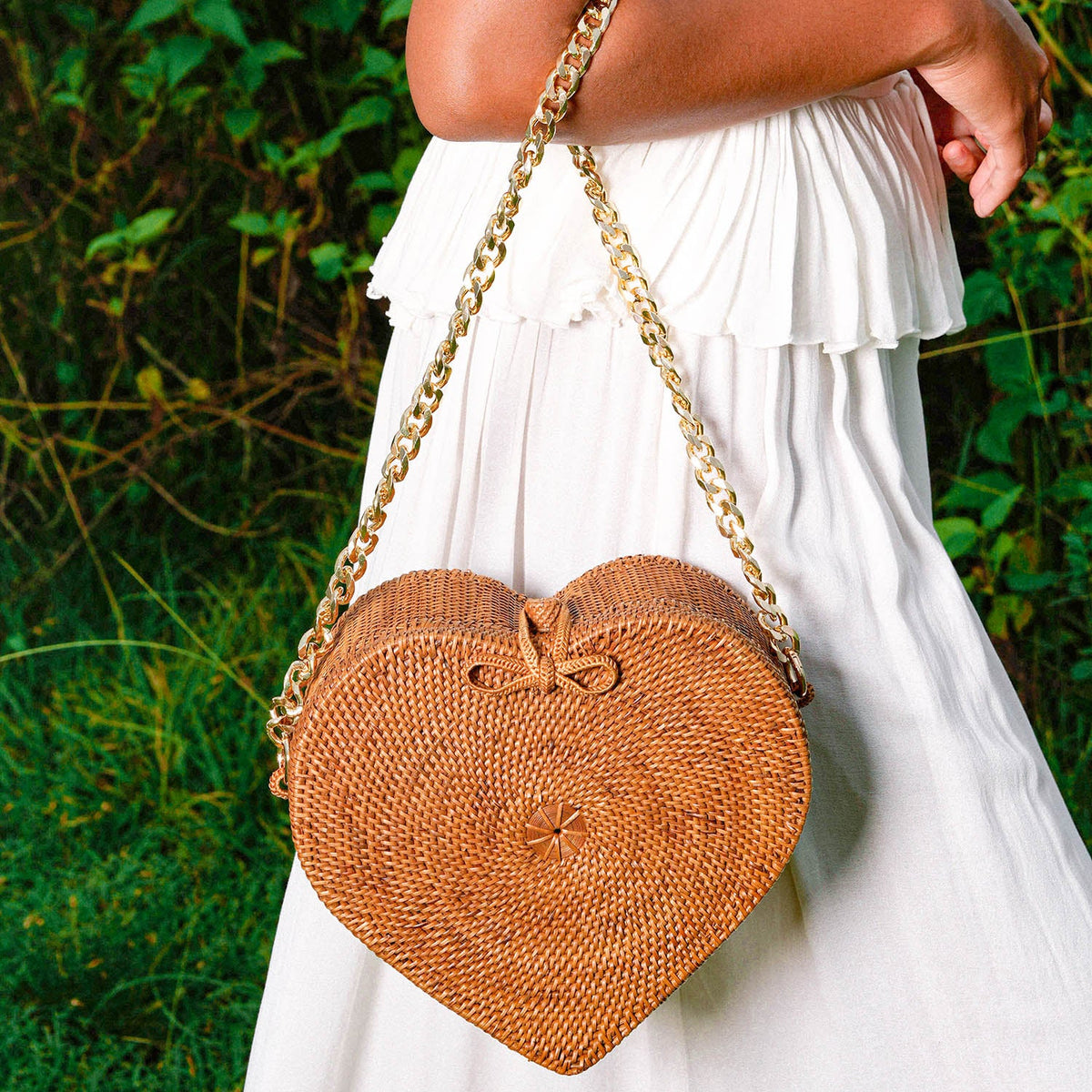 Natural brown BrunnaCo CINTA Atta rattan shoulder beach bag with gold chain strap and woven rattan design.