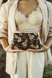 Black Sumatran Tiger Clutch Bag by BrunnaCo featuring textured faux leather and sleek design.