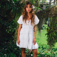 White The Srikandi Mini Ruffle Dress by BrunnaCo, featuring delicate ruffles and a stylish mini length, perfect for summer wear.