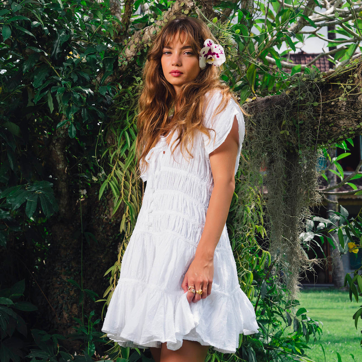White The Srikandi Mini Ruffle Dress by BrunnaCo, featuring ruffle details and a stylish mini length, shown on a model.