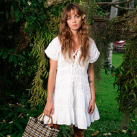 White The Srikandi Mini Ruffle Dress by BrunnaCo, showcasing its delicate ruffle details and feminine silhouette.
