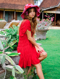 Scarlet red BrunnaCo Srikandi Ruffle Dress with flowing fabric and ruffled sleeves, perfect for elegant occasions.