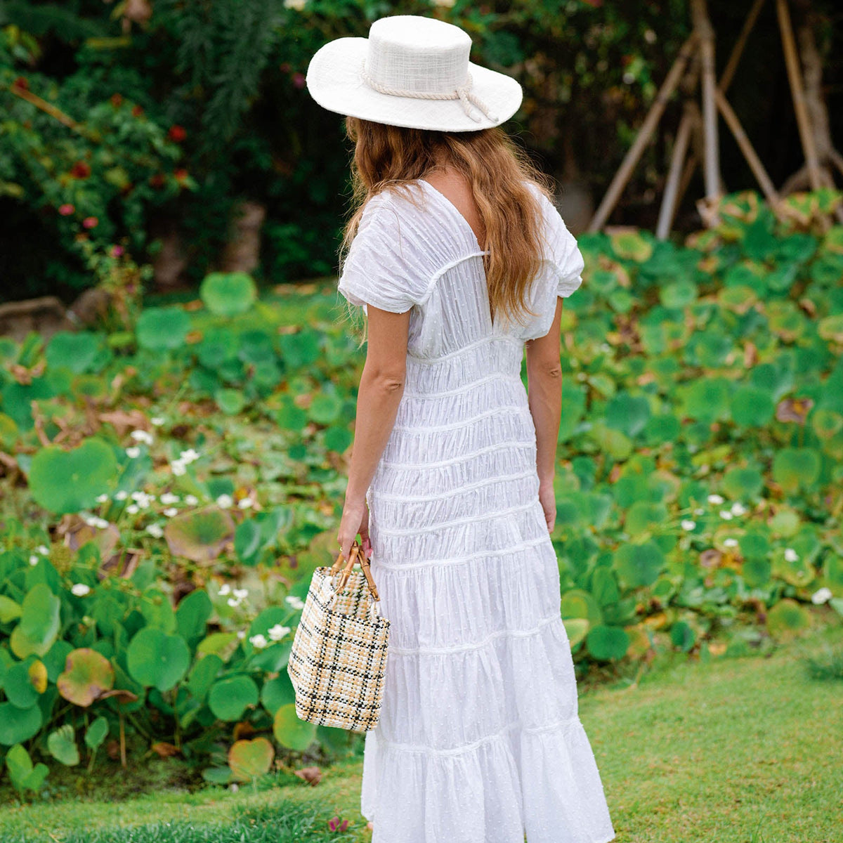 White The Srikandi Ruffle Maxi Dress by BrunnaCo featuring flowing fabric and ruffle details, full-length dress on a model.