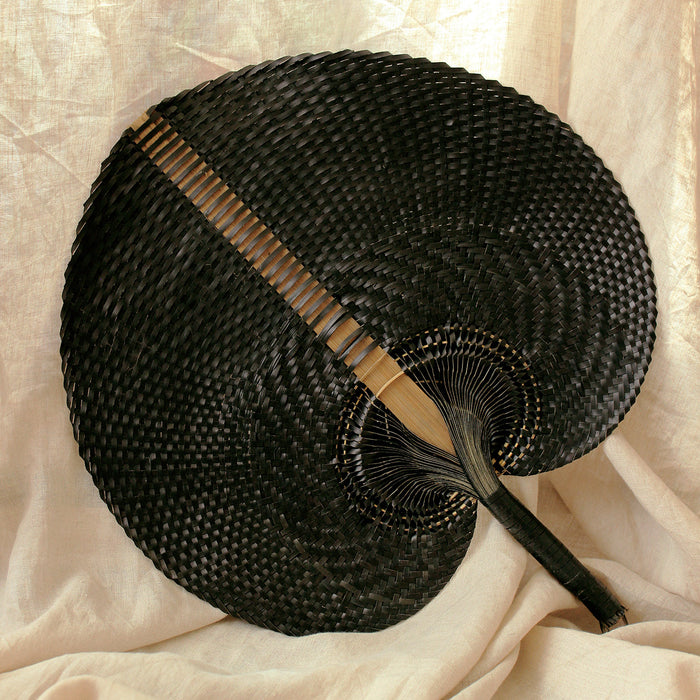 BrunnaCo NOIR Balinese woven hand fan with intricate natural fibers and detailed craftsmanship.
