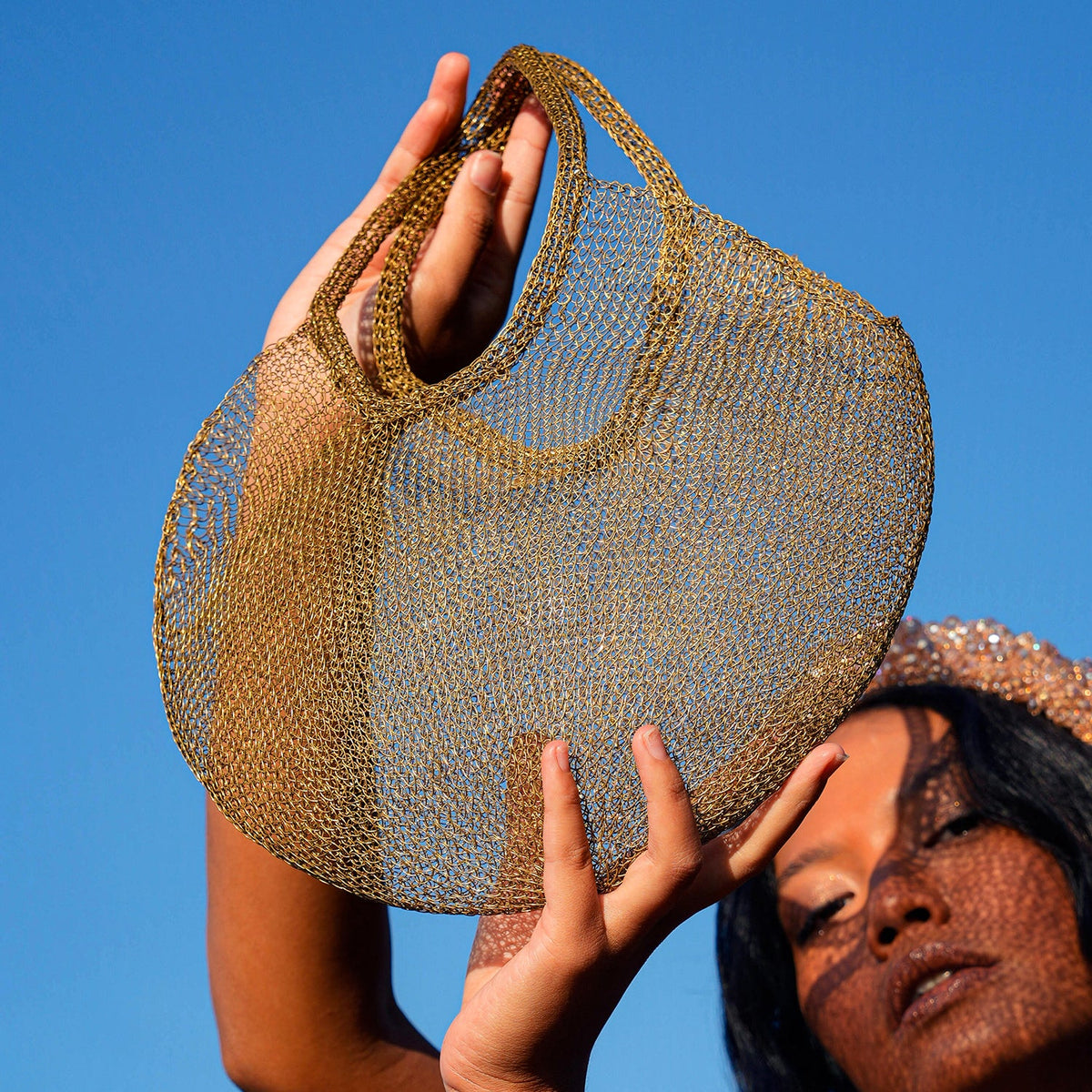 Dark gold mesh wire tote bag by BrunnaCo featuring a spacious hand-held design and sturdy handles.