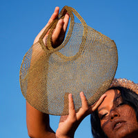 Dark gold mesh wire tote bag by BrunnaCo featuring a spacious hand-held design and sturdy handles.