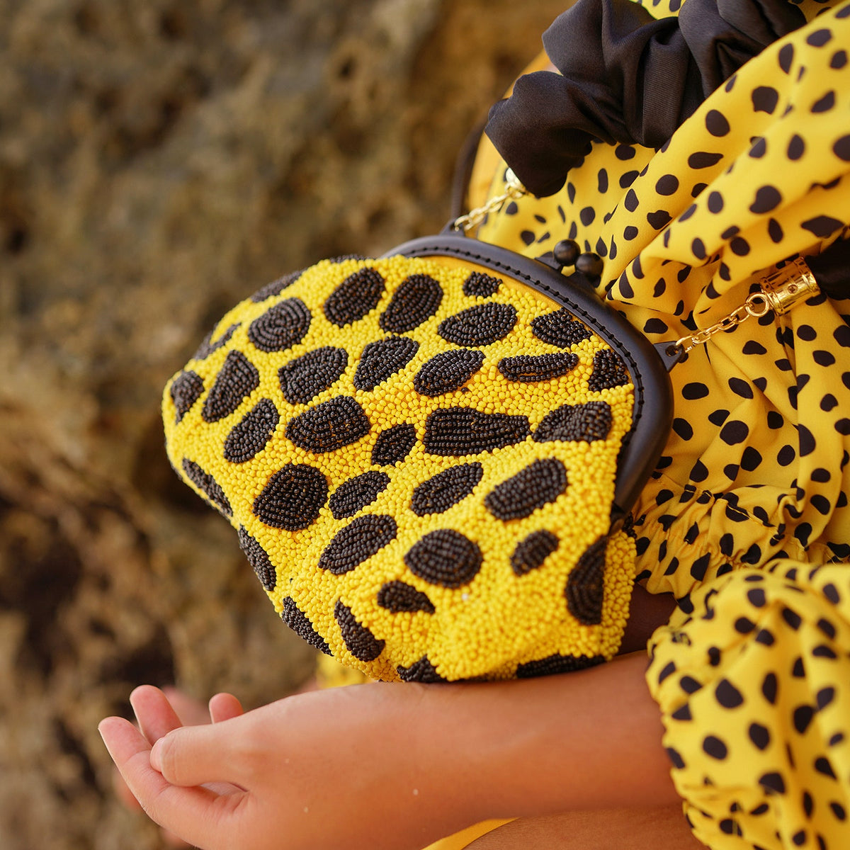 BrunnaCo Arnoldi Venom clutch bag in black and yellow with polka dots and glass bead accents, stylish handbag for evening occasions.