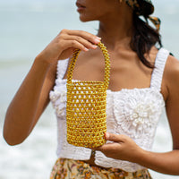 BrunnaCo GOLDA metallic beads bucket tote bag in gold with a stylish, rounded design and elegant handle details.