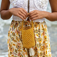 Gold metallic beads bucket tote bag by BrunnaCo featuring a shiny gold finish and stylish hand handle.