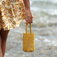 BrunnaCo GOLDA metallic beads bucket tote bag in gold with shiny beaded design and structured handle.