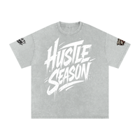 Built From Pain Hustle Season snow washed oversized cotton T-shirt displayed on a hanger, showcasing its relaxed fit and textured fabric.